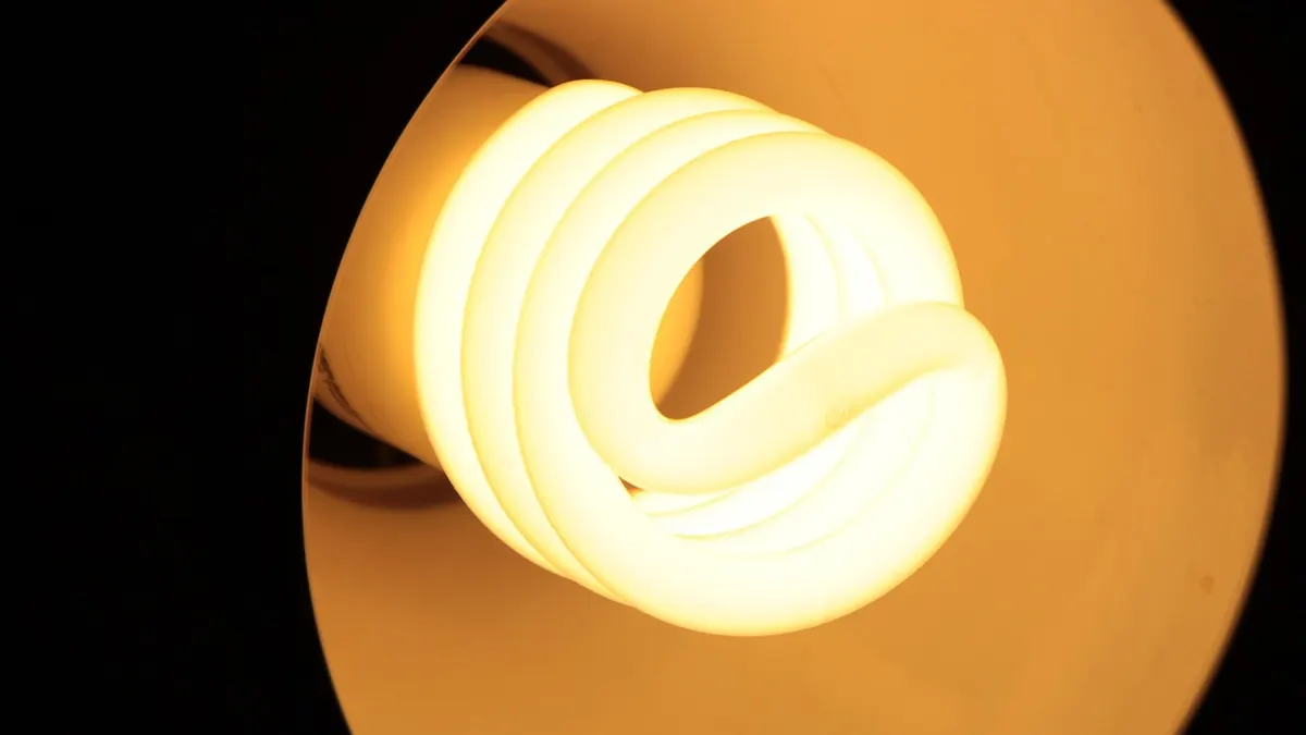 Lâmpada fluorescente compacta em espiral acesa com luz quente